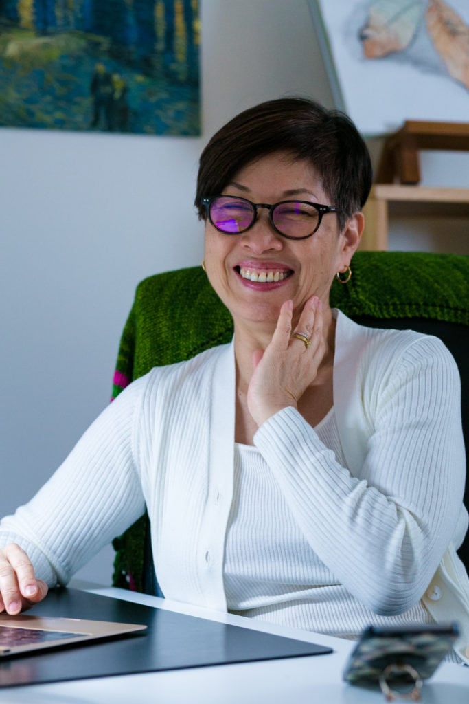 Liz Noh smiling while scrolling on computer